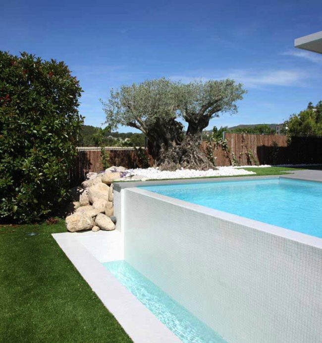 Piscina con lato sfioro cascata