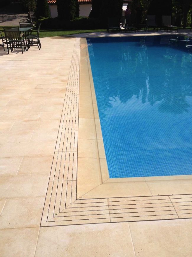 Piscina a sfioro con griglia in gres